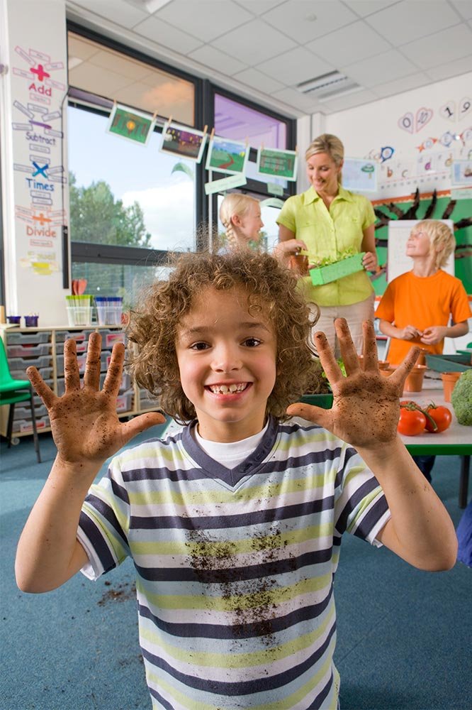 smiling-boy-shows-muddy-hands-in-classroom-2026-01-11-08-37-51-utc.jpg