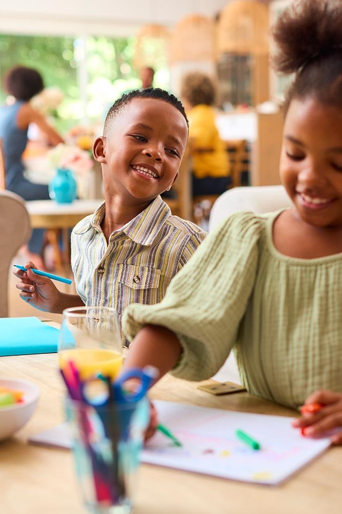 smiling-children-drawing-with-markers-at-table-ind-2026-01-05-06-31-12-utc.jpg